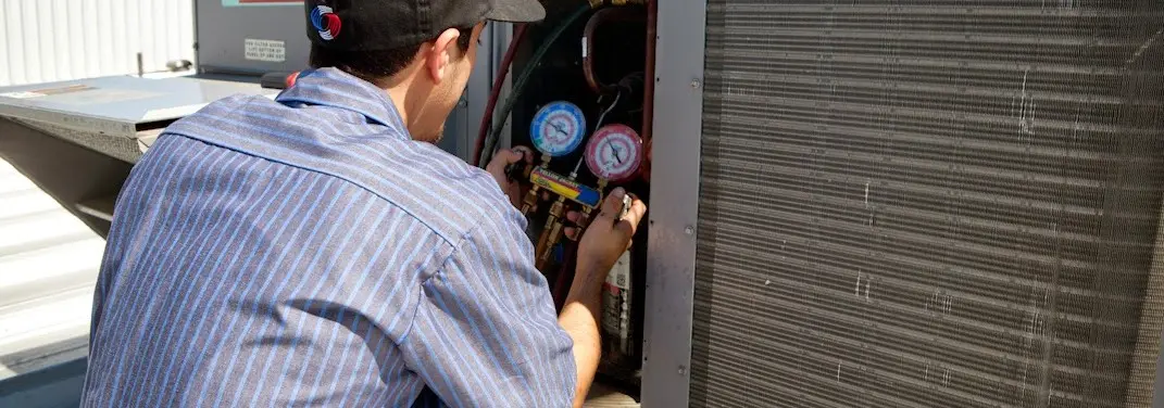 HVAC technician servicing a condenser unit in Stephenville