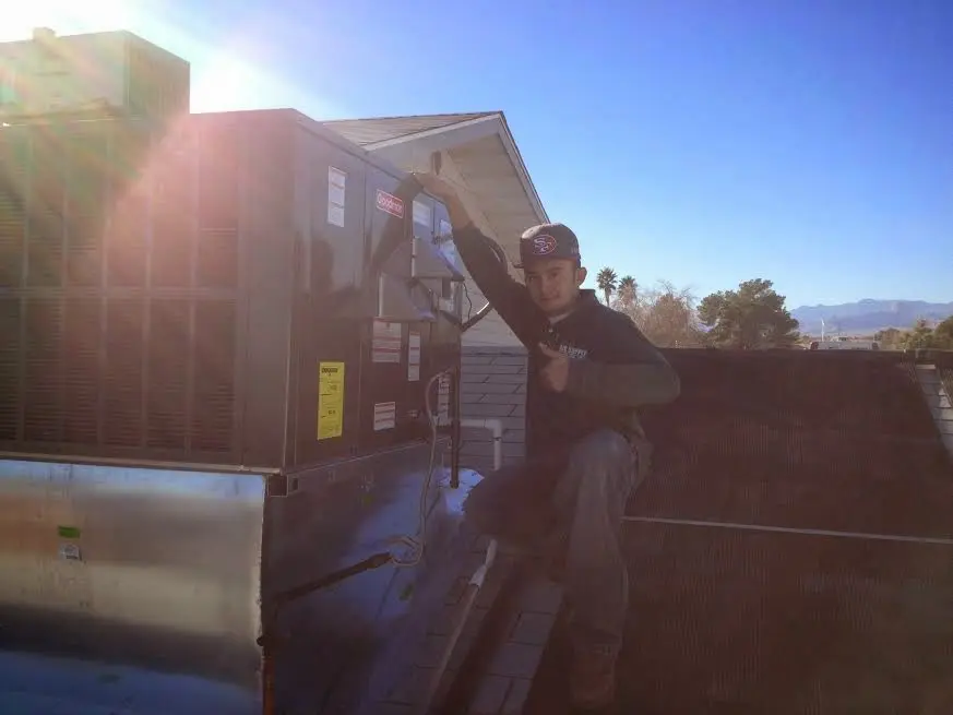 HVAC technician performing AC Tune-Up on a rooftop unit in Stephenville